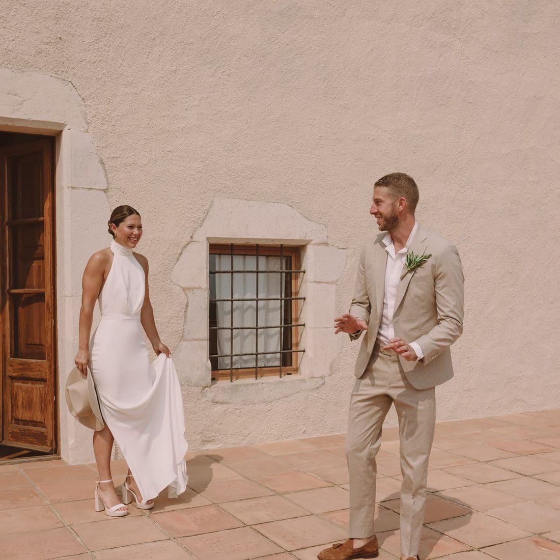 Els nuvis, somrients, davant d’una façana antiga el dia del casament