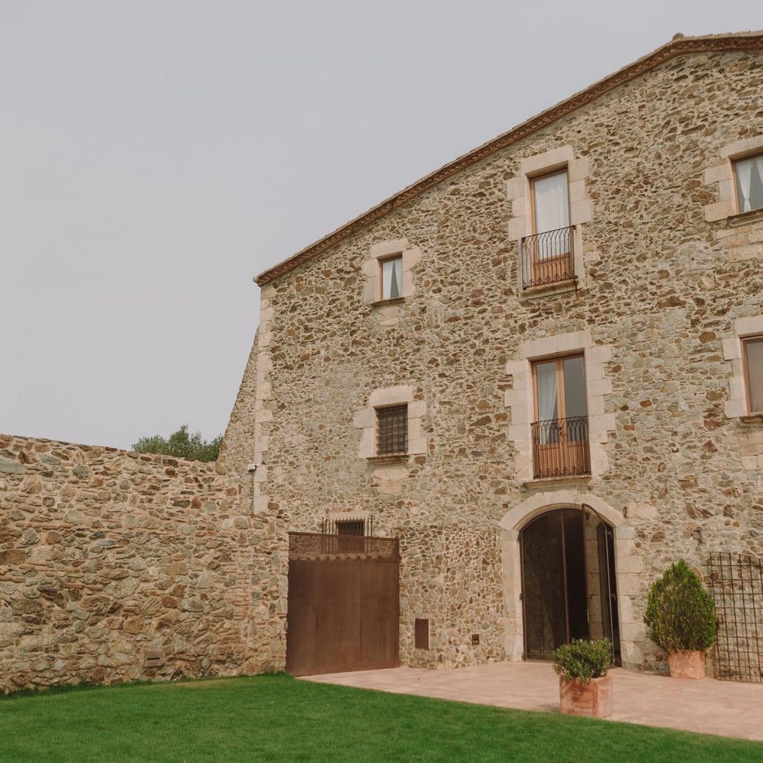Masia de pedra amb jardí de gespa on se celebra un casament