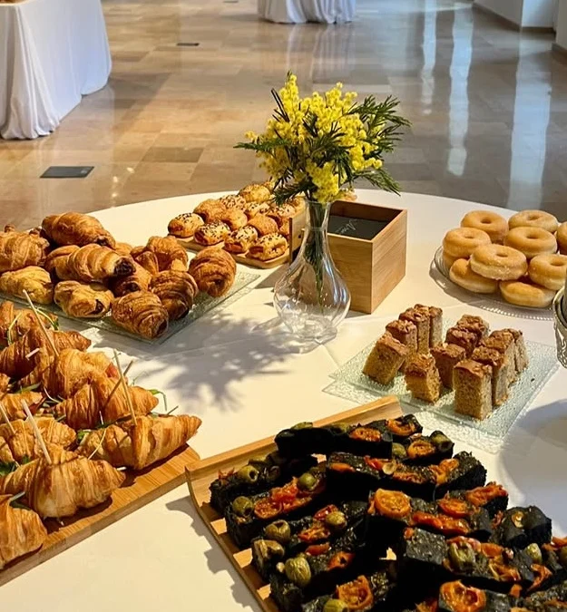 Bufet d'esmorzar amb croissants, brioixeria, donuts i coca amb olives