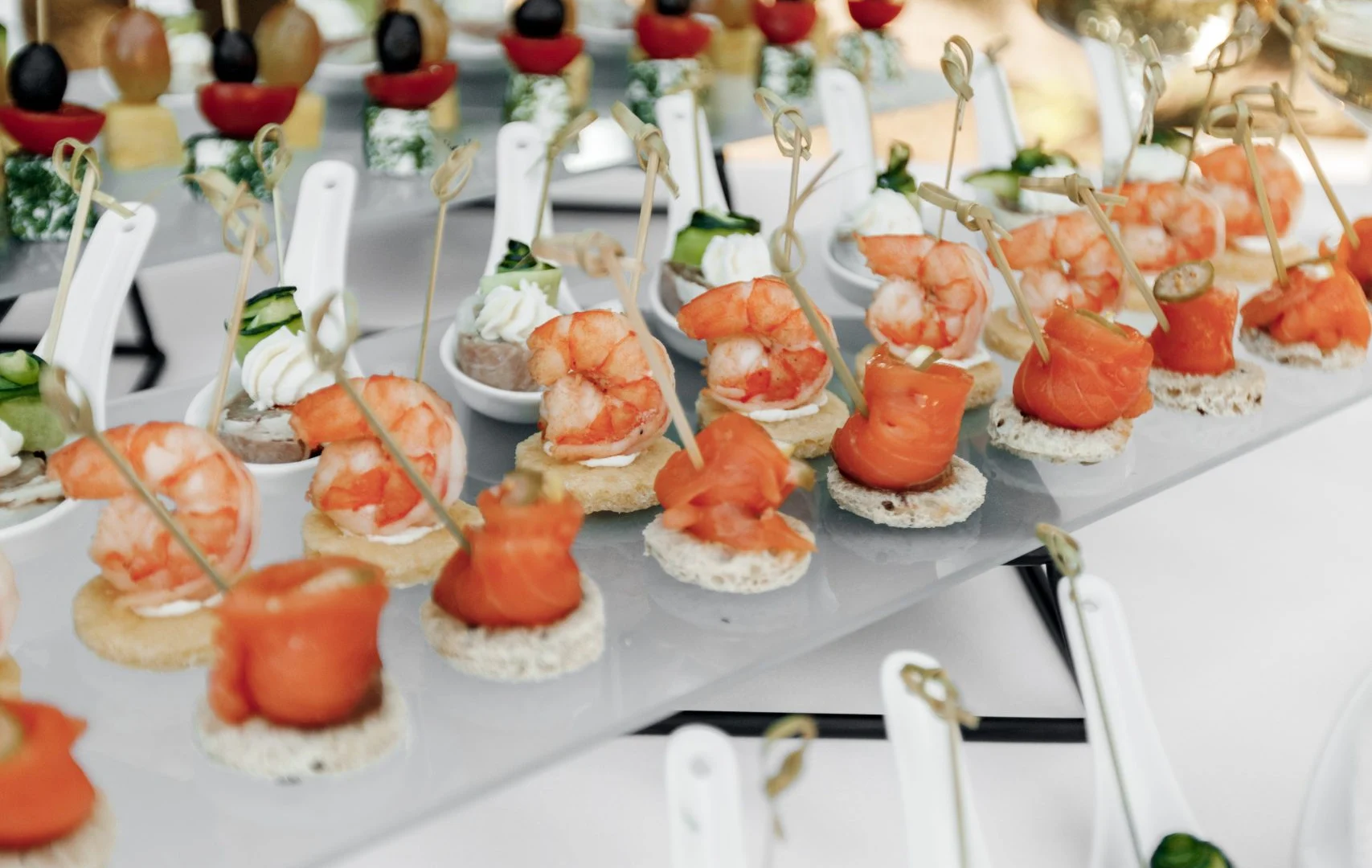 Bufé de canapés con langostinos, salmón ahumado, pinchos de aceituna y cucharillas