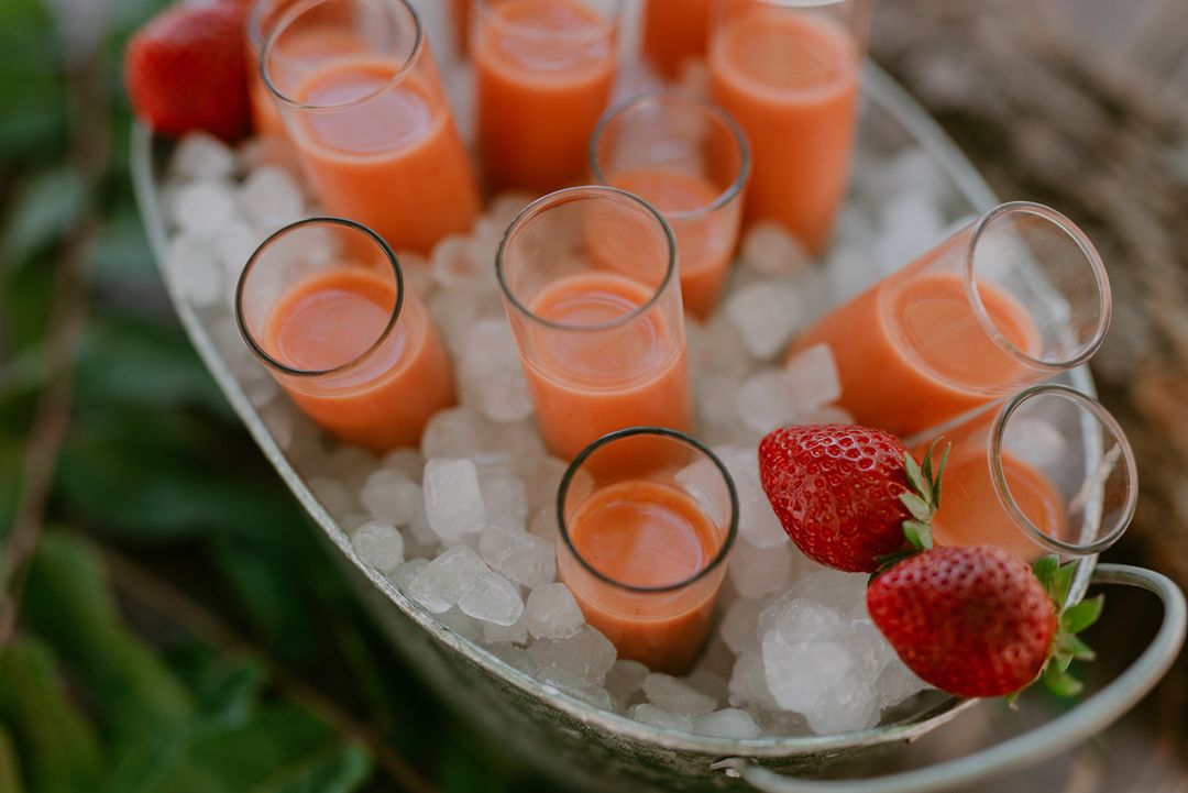 Shot glasses of chilled soup on crushed ice with fresh strawberries