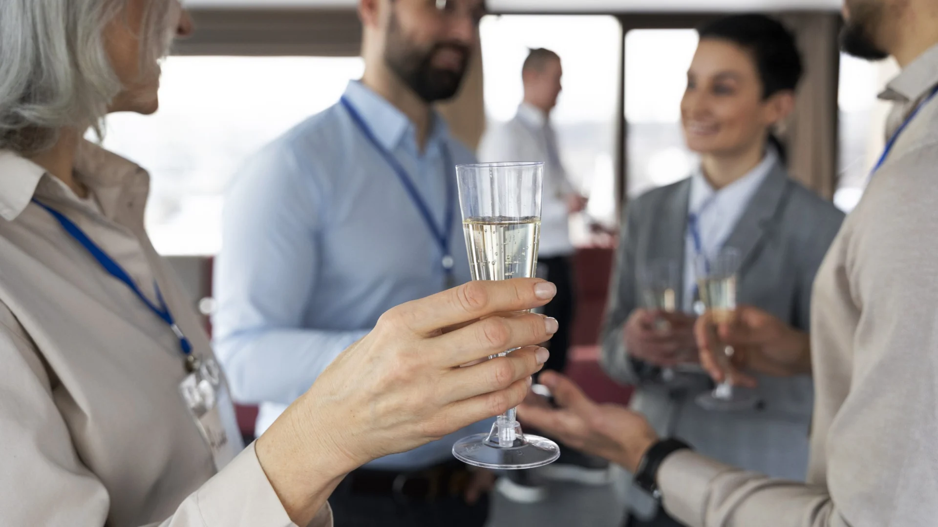 Assistents amb acreditació brindant amb copes de cava en un acte d'empresa