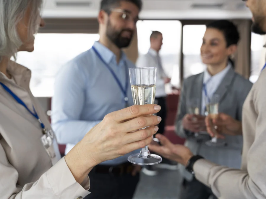 Assistents amb acreditació brindant amb copes de cava en un acte d'empresa