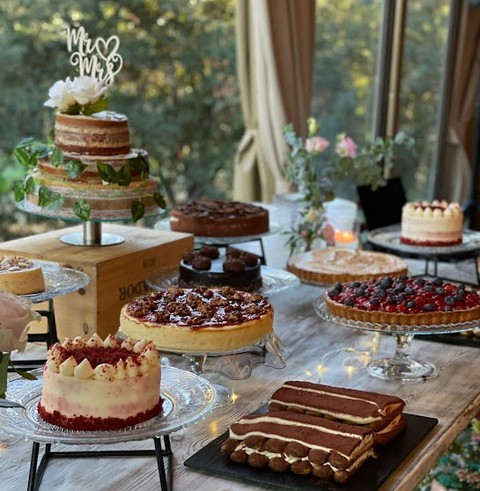Taula de postres amb pastís nupcial de tres pisos i diverses tartes