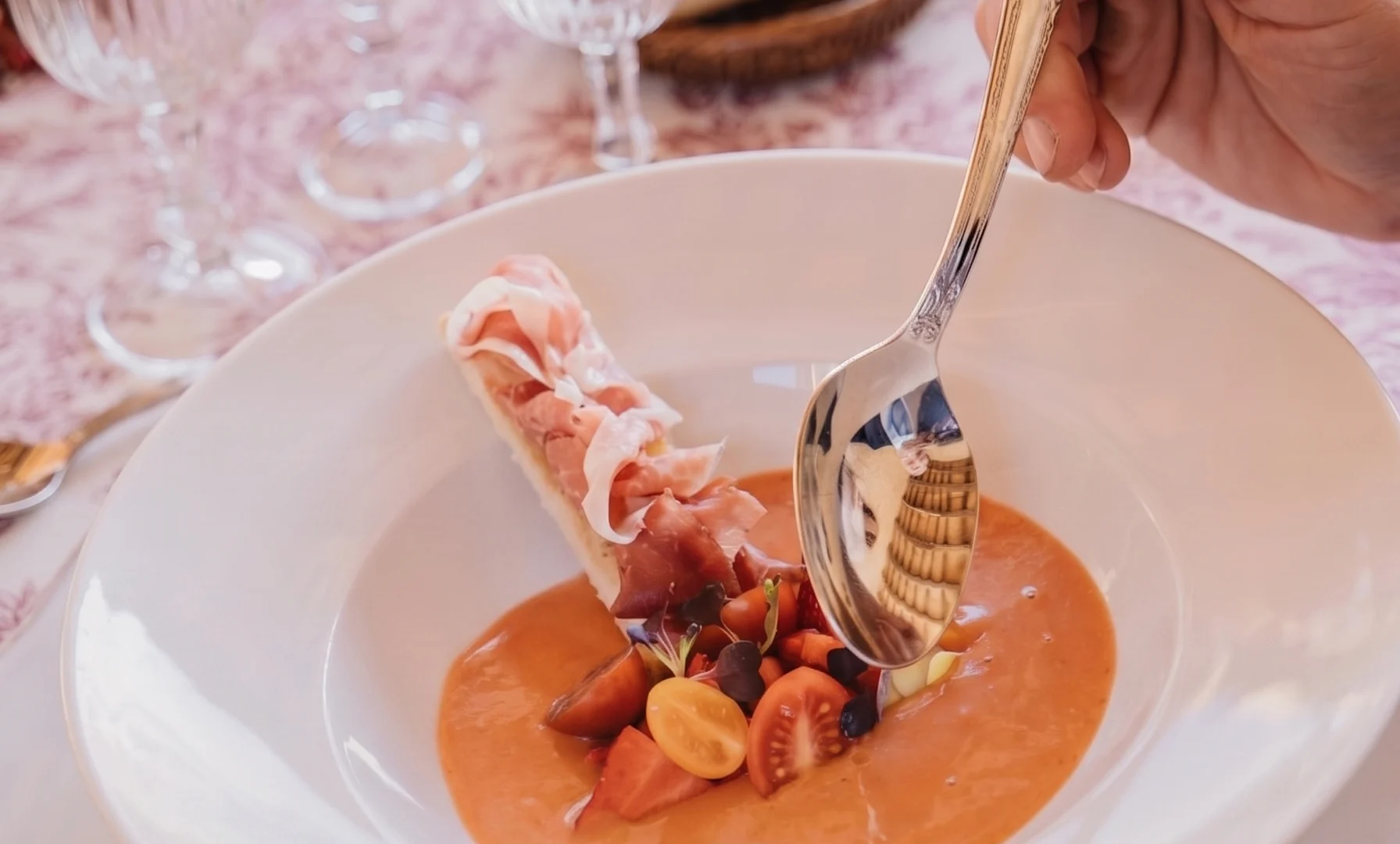 Plat de sopa freda de tomàquet amb tomàquets cherry i un rotllet de pernil
