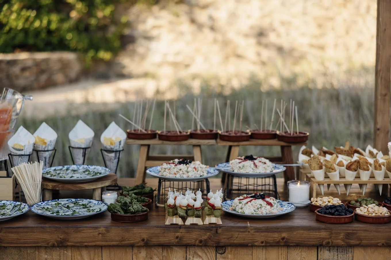 Bufé en mesa de madera con platos de arroz, conos y pinchos