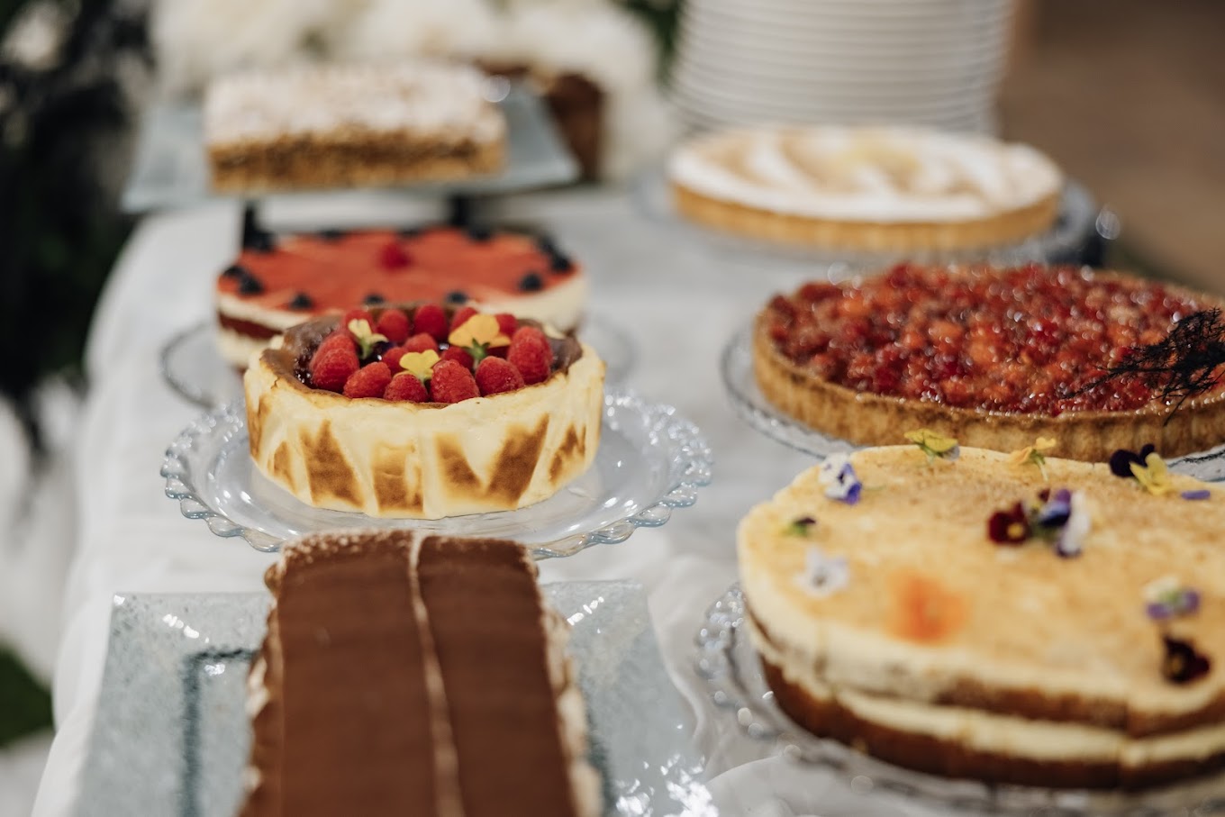 Pastissos sobre peus de vidre amb maduixes, fruits vermells i flors comestibles